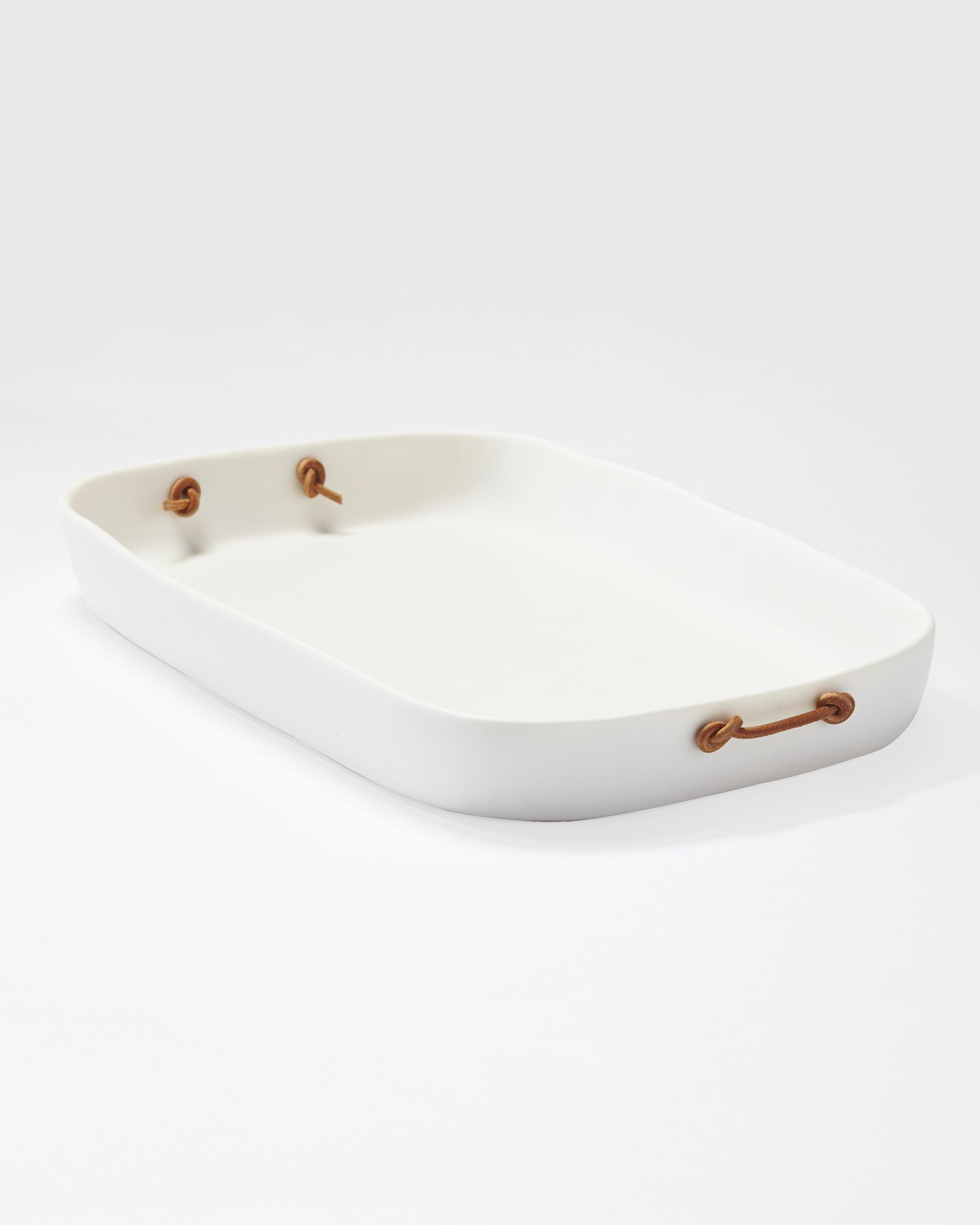 angle view of white resin tray with leather handles