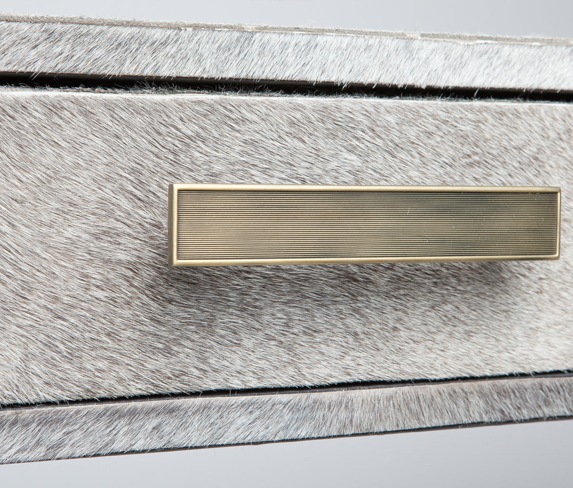 closeup of hair-on-hide texture and brushed metal drawer handle