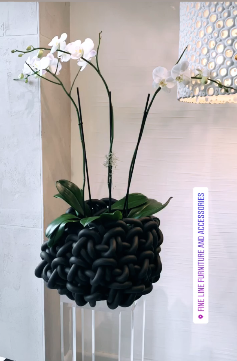 oversized black woven basket with orchids inside