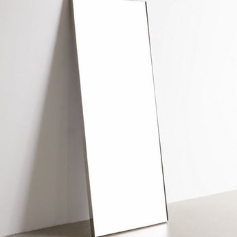 rectangular floor mirror leaned against wall with stainless steel frame