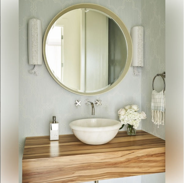 ivory-framed mirror hung above sink