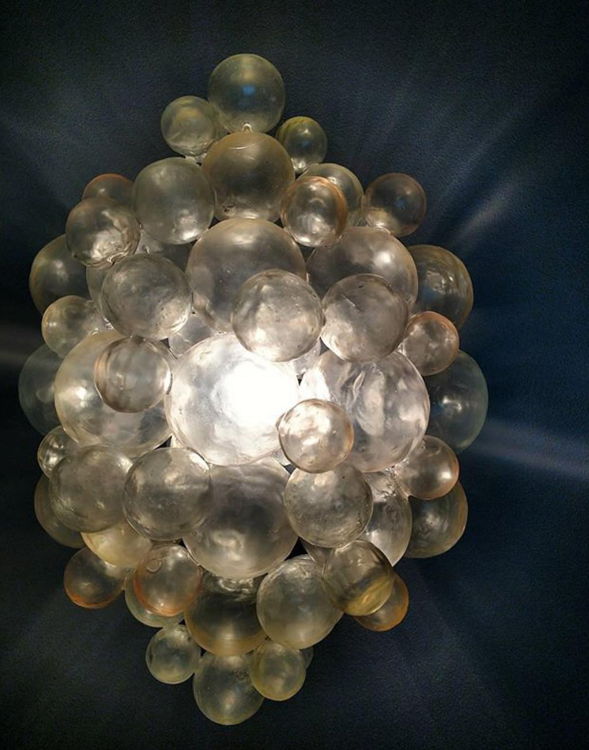 bubble sconce lit up on wall in dark room