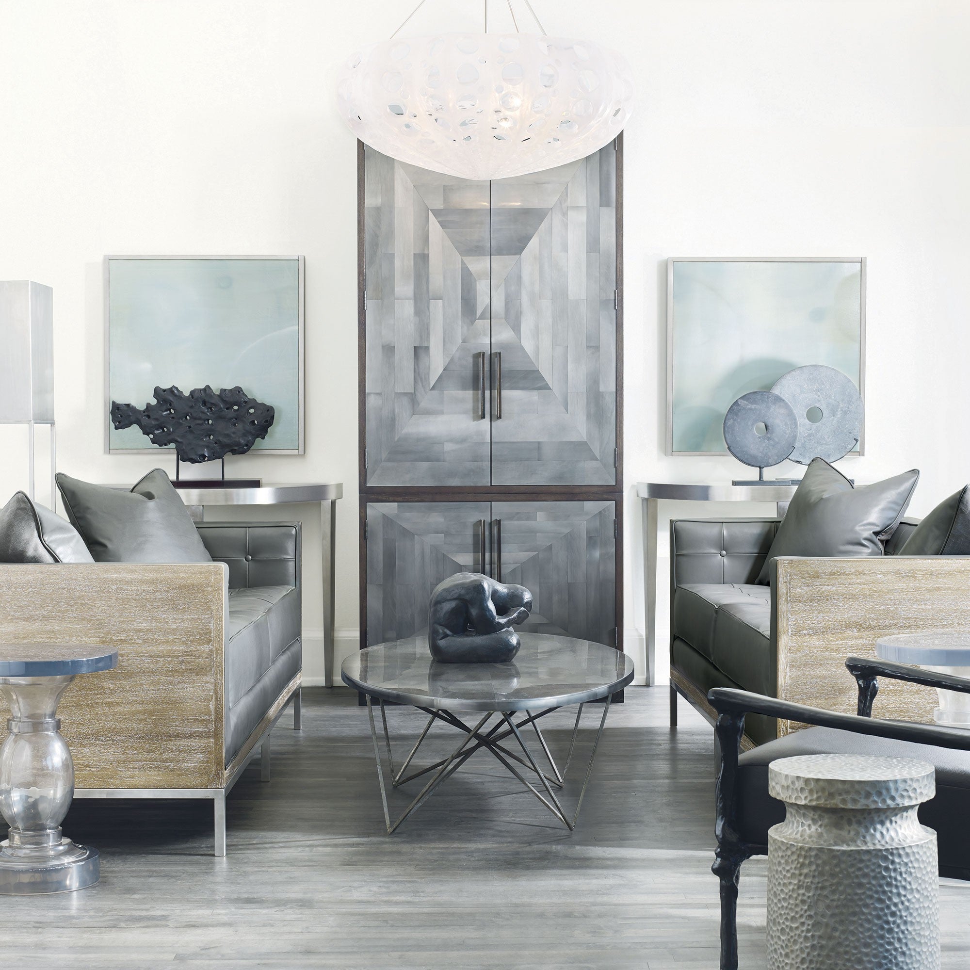 armoire showcased in sitting room behind two loveseats and coffee table