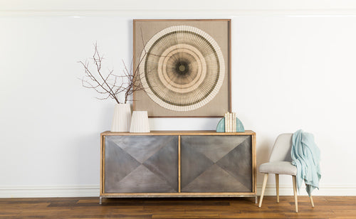 cabinet styled with decor below wall art