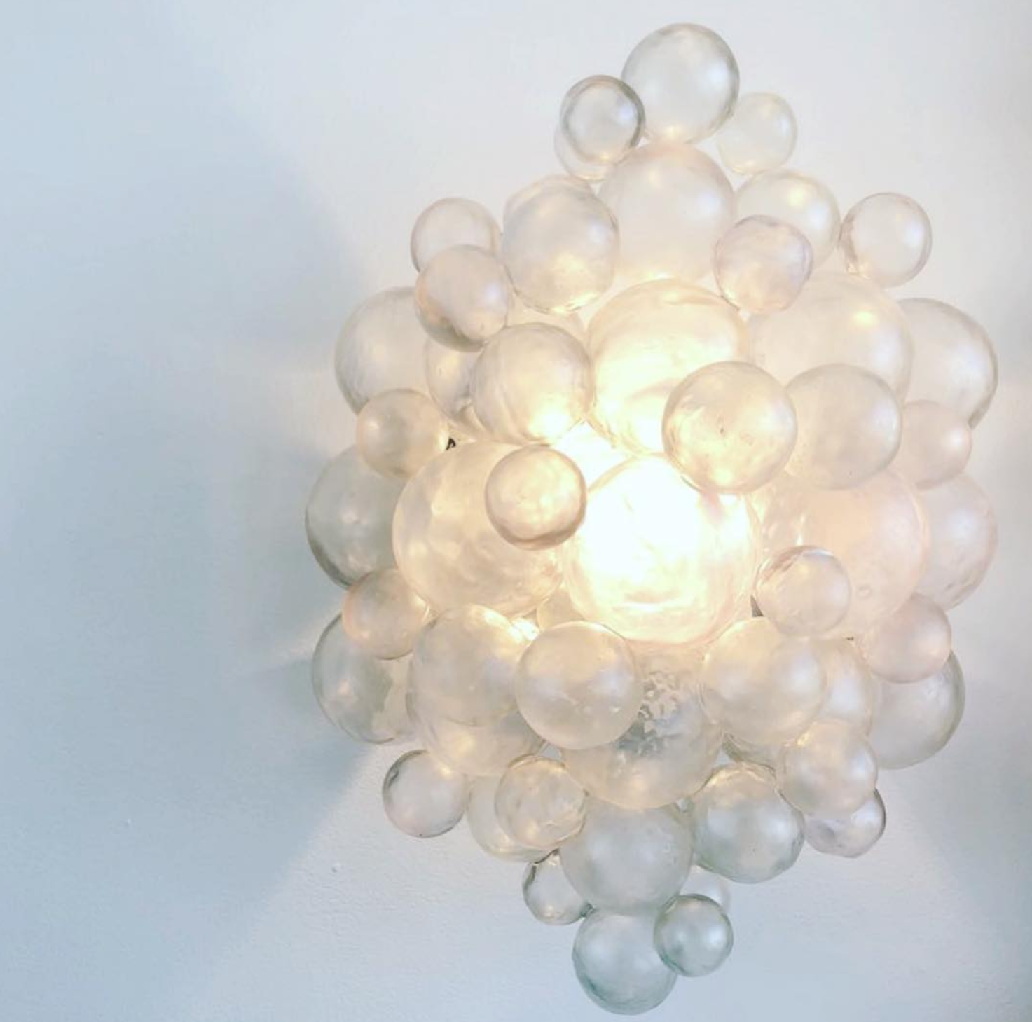 clear resin bubble sconce lit up on wall